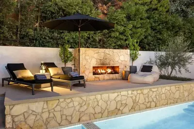 a patio with couches and a fireplace next to a pool at Hollywood Hills Villa by Universal - Pool - Dogs OK in Los Angeles