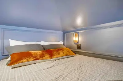 a bedroom with a white bed with a blue wall at Projector - Pool Table - 15min DT - Pets OK - BBQ in Los Angeles