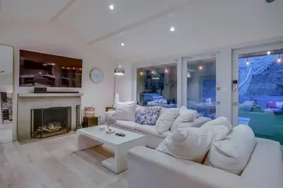 a living room with white furniture and a fireplace at Hollywood Hills Retreat - Private GYM & STEAM ROOM in Los Angeles