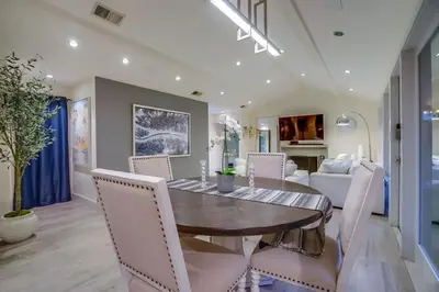 a dining room with a wooden table and white chairs at Hollywood Hills Retreat - Private GYM & STEAM ROOM in Los Angeles