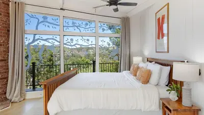a bedroom with a white bed and a large window at Designer Retreat w Pool Firepits Panoramic Views The Lake House at Malibu in Agoura Hills