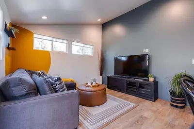 a living room with a couch and a flat screen tv at New and Modern Casita VIP in San Dimas