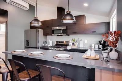 a kitchen with a large counter with chairs and appliances at New and Modern Casita VIP in San Dimas
