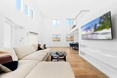 a living room with a couch and a tv on a wall at The Diamond Dune Three floors Two Balconies BBQ in Los Angeles