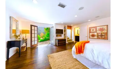 a large bedroom with a bed and a desk and a desk at Hollywood Hills Spa Retreat Oasis with Tree Top Views, Private Jacuzzi Style Tub, Steam Room, Magical Half Acre Acre Garden and Patio, Free Parking for 2 cars, in LA's most Serene, Central Desirable Area in Los Angeles