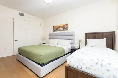 a white bedroom with two beds at Snug 3BR HighRise with Pool, Spa & Rooftop Views in Los Angeles