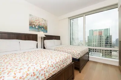 a bedroom with two beds and a large window at Snug 3BR HighRise with Pool, Spa & Rooftop Views in Los Angeles