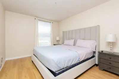 a white bedroom with a large bed and a window at Cozy 2BR Apt in Downtown LA with Pool & Hot Tub in Los Angeles