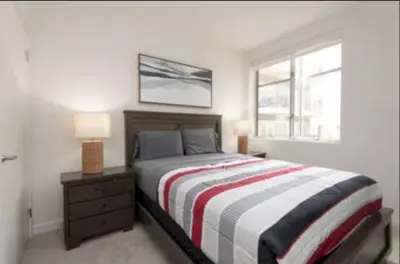 a bedroom with a bed and a nightstand and a window at Walk to Santa Monica Beach Pier Boardwalk Venice in Los Angeles