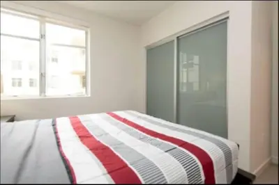 a bedroom with a bed with a red and white striped blanket at Walk to Santa Monica Beach Pier Boardwalk Venice in Los Angeles