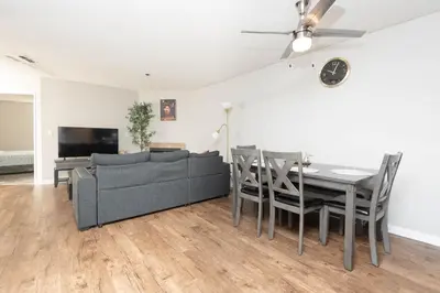 a living room with a table and a couch and a television at 2BR Hollywood Apt with Rooftop Pool & Stunning Views in Los Angeles