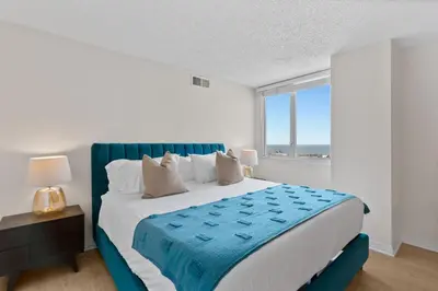 a bedroom with a blue and white bed with a window at The Amethyst Retreat Ocean Marina Panoramic View in Los Angeles