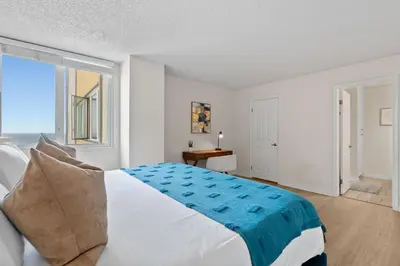 a white bedroom with a bed and a window at The Amethyst Retreat Ocean Marina Panoramic View in Los Angeles