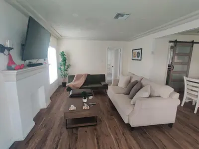 a living room with a white couch and a table at sofi intuit cozy home free parking queen beds in Inglewood