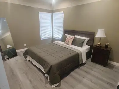 a bedroom with a bed and a lamp and a window at sofi intuit cozy home free parking queen beds in Inglewood