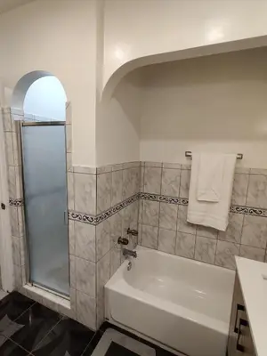 a bathroom with a shower and a white bath tub at sofi intuit cozy home free parking queen beds in Inglewood