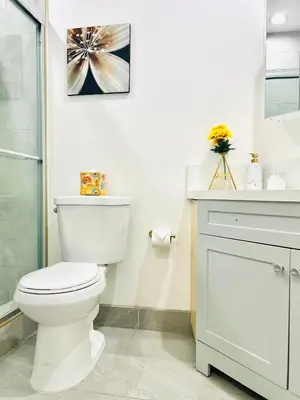 a white bathroom with a toilet and a sink at LA Modern Street View Glass Window 2BR in North Sherman Way