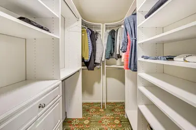 a walk in closet with white cabinets and a rug at Walk to Private Beach Rancho Palos Verdes Escape! in Rancho Palos Verdes
