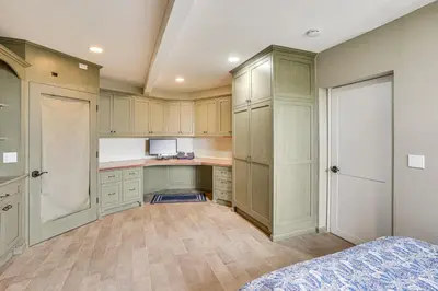 a kitchen with wooden cabinets and a bed in a room at Walk to Private Beach Rancho Palos Verdes Escape! in Rancho Palos Verdes