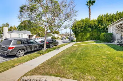a street with cars parked in a residential neighborhood at 4 Mi to SoFi Stadium Pet-Friendly LA Area Home in Los Angeles