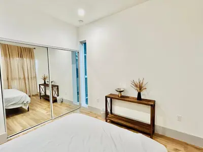 a white bedroom with a mirror and a bed at Newly Built Modern Central 2B On Sherman with Free Parking in North Sherman Way