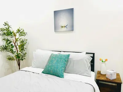 a white bed with a blue pillow on it at Newly Built Modern Central 2B On Sherman with Free Parking in North Sherman Way