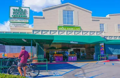 a man walking a bike in front of a store at Cozy Private Guest House in Los Angeles