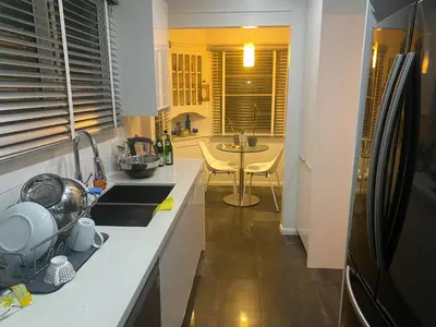 a kitchen with a refrigerator and a table in it at Spanish Cottage on Rosewood Avenue, Los Angeles , Melrose Village in Los Angeles