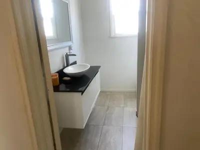 a bathroom with a sink and a mirror and a window at Spanish Cottage on Rosewood Avenue, Los Angeles , Melrose Village in Los Angeles