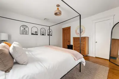 a bedroom with a white bed with a black frame at Bright Coastal Escape 4 Bedroom 2 Bath Near CSULB Long Beach Airport and Beach in Long Beach