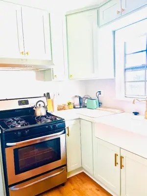 a kitchen with a stove and white cabinets at Honeywood in Hollywood! in Los Angeles