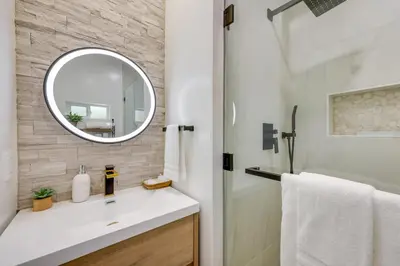 a bathroom with a white sink and a mirror at Walk to Big Bear Marina Modern Home with Hot Tub! in Big Bear Lake