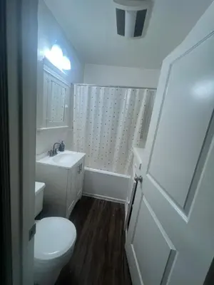 a white bathroom with a toilet and a sink at Living downtown in Long Beach