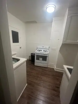 a small kitchen with a stove and white cabinets at Living downtown in Long Beach