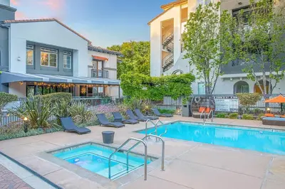 a swimming pool with chairs next to a house at Premier Suites at Marina-Venice with Luxe Pool, Gym & Hot Tub & More in Los Angeles