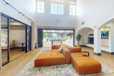 a living room with an orange couch and a table at Premier Suites at Marina-Venice with Luxe Pool, Gym & Hot Tub & More in Los Angeles