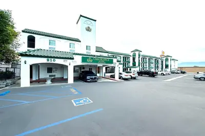 a parking lot in front of a building with cars parked at Casa Blanca Hotel - Corona in Corona