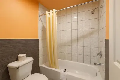 a bathroom with a toilet and a tub and a shower at Casa Blanca Hotel - Corona in Corona