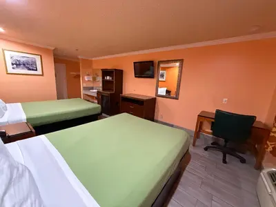 a hotel room with two beds and a desk and a chair at Casa Blanca Hotel - Corona in Corona