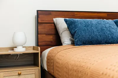 a bed with a blue pillow and a night stand at Stunning 2BR apartment steps from Santa Monica pier in Los Angeles