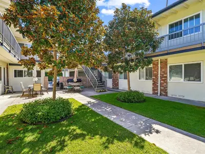 a house with a tree in the yard at Beautiful 2 Bed Beach Condo #104 in Carpinteria