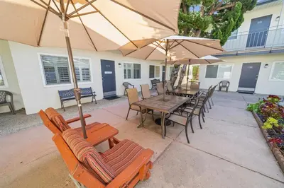 a patio with a table and chairs and umbrellas at Beautiful 1 Bed Beach Condo #122 in Carpinteria