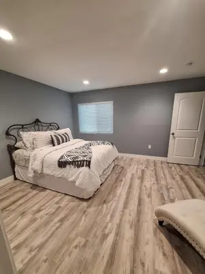 a bedroom with a bed and a wooden floor at My amazing home in Azusa