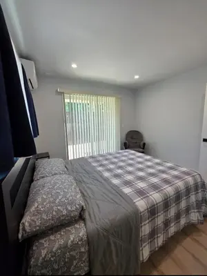 a bedroom with a large bed with a plaid blanket at WG House Winnetka Los Angeles in Winnetka