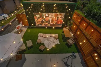 an overhead view of a backyard with a picture of a family at La Tierra House 15 Min to Beach Movie Lounge in Hawthorne
