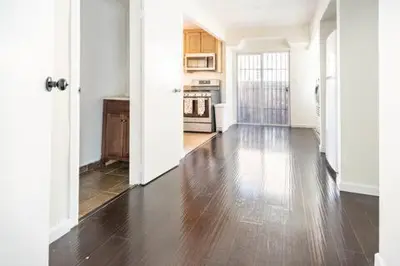 a kitchen with a wooden floor and white walls at Urban Casita in Los Angeles