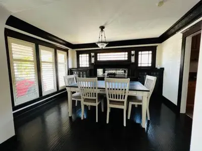 a dining room with a table and chairs and windows at Urban Casita in Los Angeles
