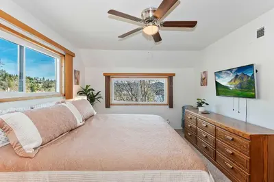 a bedroom with a bed and a ceiling fan at Acorn Acres - Lake Views for 8 in Lake Arrowhead