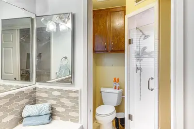 a bathroom with a toilet and a glass shower at 7 Mi to Dtwn Poolside Paradise in Bakersfield! in Bakersfield