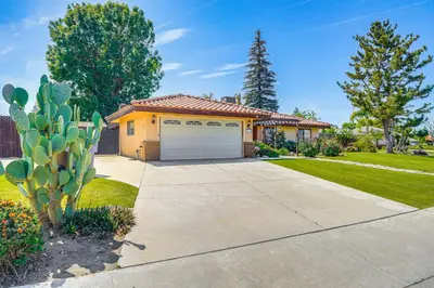 a house with a garage and a cactus at 7 Mi to Dtwn Poolside Paradise in Bakersfield! in Bakersfield